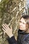 Girl hugging a huge tree trunk in the Park, smiling at the camera. The concept of protection of nature