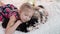 Girl hugging husky puppies lying