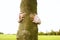 Girl hugging tree in park.