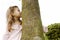 Girl hugging tree in park.