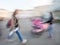 Girl hurrying and women with a baby in a stroller