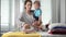 Girl ironing clothes. Young woman ironing yellow dress, small child boy sitting in her arms