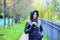 Girl in jacket with hood, holding a coffee or tea, young enjoys the outdoors and sports, spring autumn, lifestyle, blac