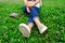 Girl in jeans in casual flats resting on green grass