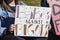 Girl in jeans jacket holding homemade sign - Babes against Bigots - with stars and jewels on it