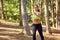 A girl jogging in the woods outdoors.