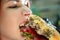 Girl with a juicy burger. Close up portrait of a smiling hungry young woman eating burger.