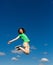 Girl jumping, running against blue sky