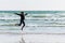 Girl jumping on the shore, Atlantic Ocean. Brittany, France.