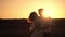 Girl jumps into her husband arms against romantic sunset background