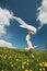 Girl jumps over dandelion field