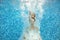 Girl jumps and swims in pool underwater, child has fun in water