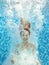 Girl jumps and swims in pool underwater, child has fun in water