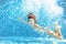 Girl jumps and swims in pool underwater, child has fun in water