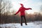 Girl jumps in wood in winter from back