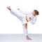 Girl in karategi trains a kick