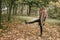 A girl kicks autumn leaves with her foot