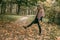 A girl kicks autumn leaves with her foot