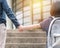Girl kid elementary student carrying backpacks holding parent mother`s hand walking up educational building`s stair