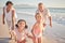 Girl, kids and happy grandparents at beach, on holiday or vacation together. Grandma, children and grandpa play by ocean