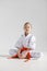 A girl in a kimono at a karate lesson, martial arts. White background, vertical