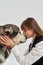 Girl kissing Siberian Husky dog in white studio