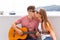 Girl kissing young guitarist.