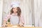 Girl in kitchen. Process of cooking buns. Little cook. White cap