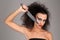 Girl with knifeand wild hair. Close up. Graybackground