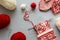 Girl knits red and white jacquard hat knitting needles on gray wooden background. Process of knitting.