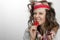 Girl with knitted hat and scarf holding with teeth a red condom