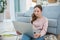 Girl with a laptop in her hands sitting on the floor.