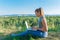 Girl with laptop on the nature on the background of forest and sky. The concept of combining leisure and work. Individual