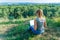 Girl with laptop on the nature on the background of forest and sky. The concept of combining leisure and work. Individual