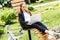 Girl with a laptop sits on the bench outdoors