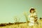 Girl in the late summer walking through a field of flowers and w