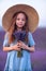 Girl lavender field in a blue dress with flowing hair in a hat stands in a lilac lavender field