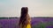 Girl in lavender flowers field at sunset in yellow dress enjoying blooming fields. France, Provence.
