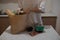 The girl lays out the products from the bag on the table. A close-up of the girl pulls groceries out of a paper bag