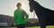 Girl leading horse on the lush green fields of the ranch