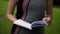 Girl leafing through a book in nature