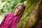 Girl leaning against a mossy tree