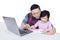 Girl learning with father using a book and laptop