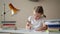 Girl learning lessons, cute girl making her homework, schoolgirl studing at home at the table