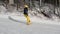 Girl learning to ride a downhill slope on a snowboard. Young girl learns to snowboard. Camera on move. People on