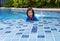 A girl learning to swim by the pool