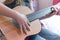 A girl learns to play guitar at home close up on hands