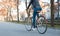 A girl in a leather jacket and jeans rides a bicycle