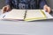 Girl at lectern desk with open binder notebook. Chequered sheets, paper. Copy space for text