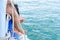 Girl legs hang off edge Passenger boat in ocean.